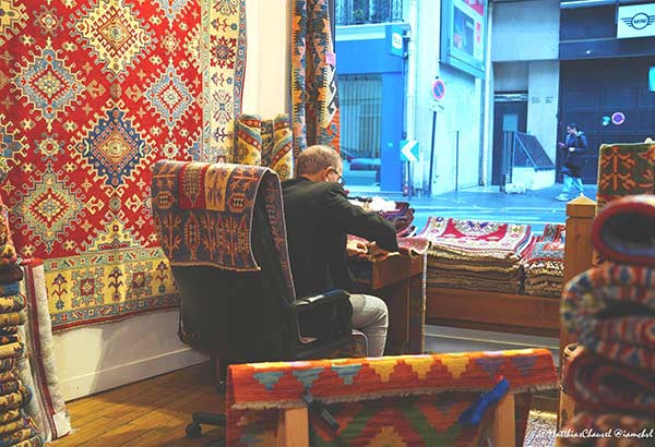 Comment restaurer un tapis iranien ancien ? Artisan réparant un tapis iranien ancien