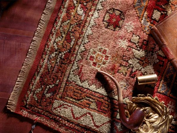 Où faire restaurer un tapis persan à Paris ? tapis oriental rouge motifs et franges
